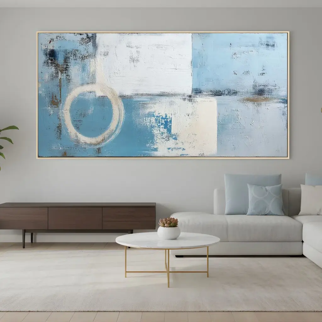 Abstract blue and white horizontal diptych above low console – A living room with a low wooden console and a wide two-panel abstract artwork in shades of blue and white on the wall.