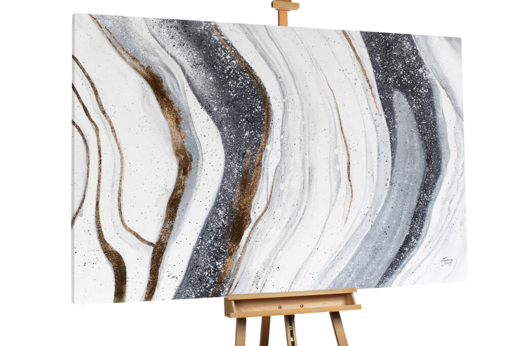 A horizontal abstract painting on an easel featuring flowing vertical bands of white, grey, and gold, resembling marble or water currents.
