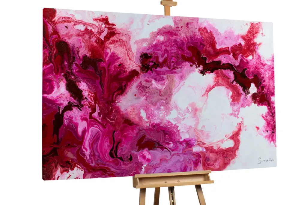A large-scale abstract painting on an easel dominated by vibrant magenta, pink, and white fluid textures.