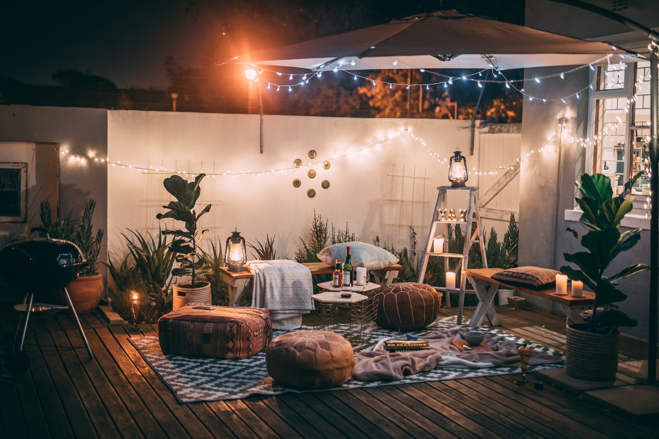 Thème de la nature en extérieur avec des accents en bois, des coussins et des lumières de fées